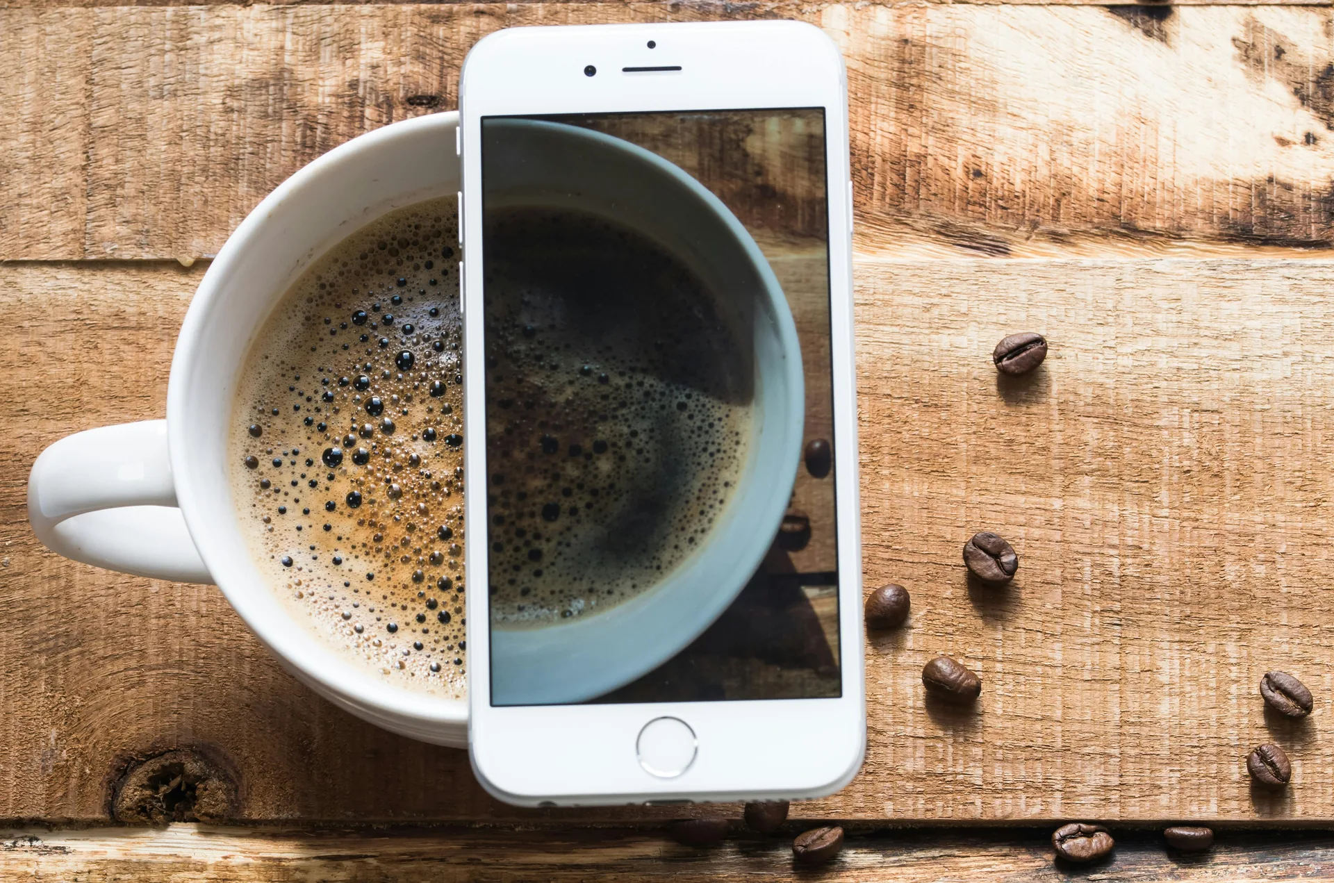 A cup of coffee beside a phone in a calm morning flat-lay