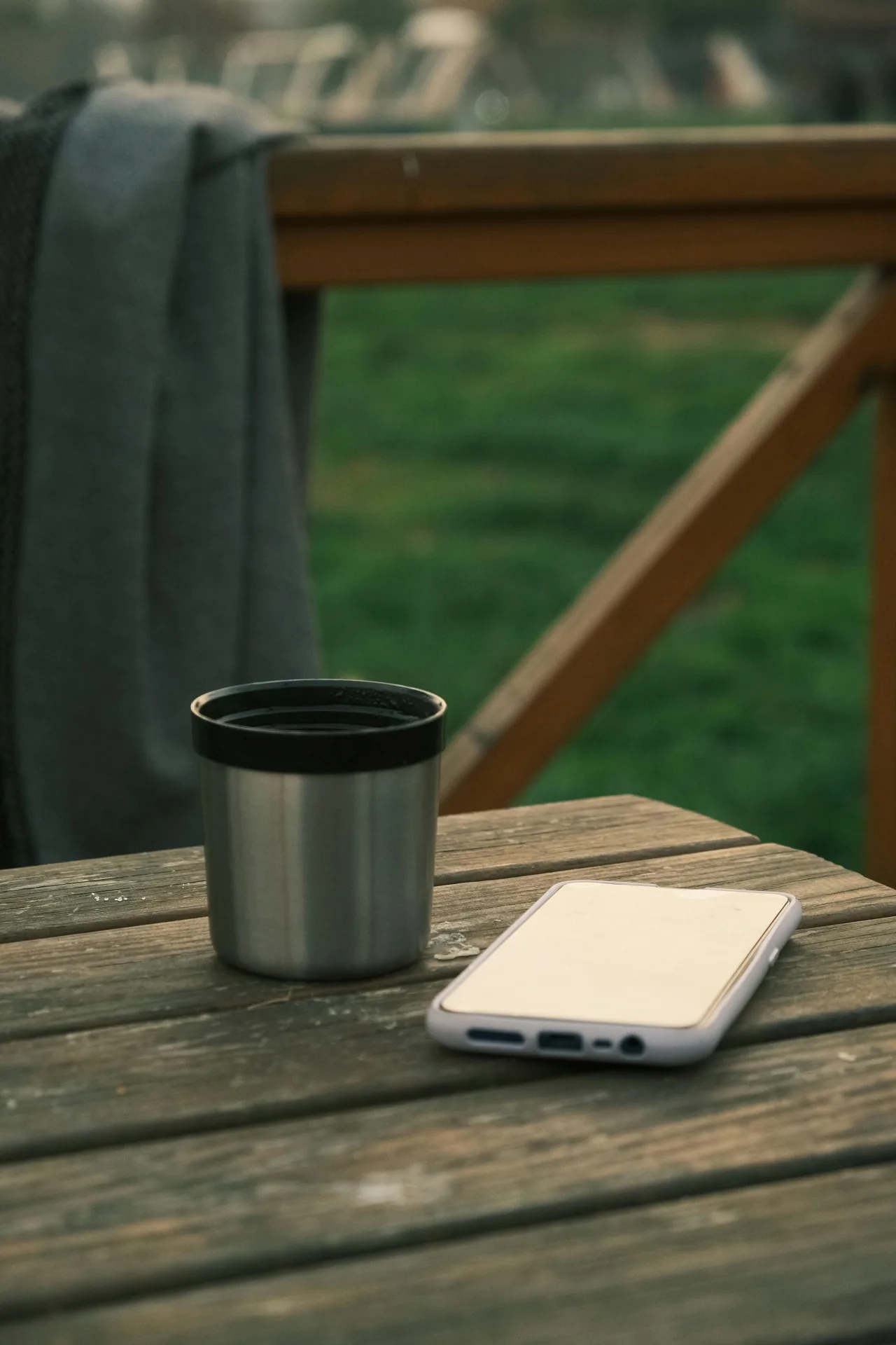 A coffee mug and phone resting on a wooden table