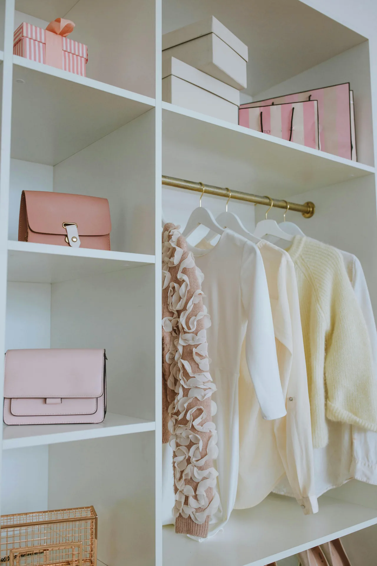 A bright white shelving closet displaying a row of handbags